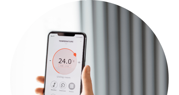 A semi circle frame of a photograph showing a handheld device displaying a app to control temperature with a radiator in the background out of focus