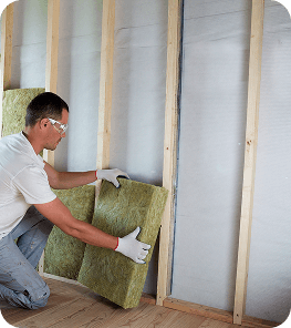 A man installing loft insulation 